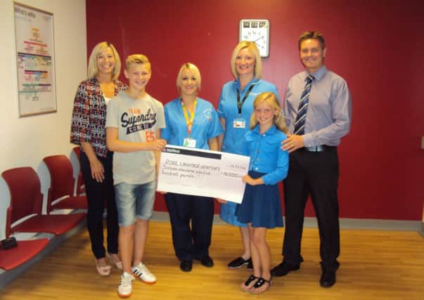 The Hood family are pictured in the entrance to the Centenary Building at the Royal Lancaster Infirmary with a presentation cheque for £16,500 from Emilys Starlite, and with Debbie Dickson and Staff Nurse Katie Smith.