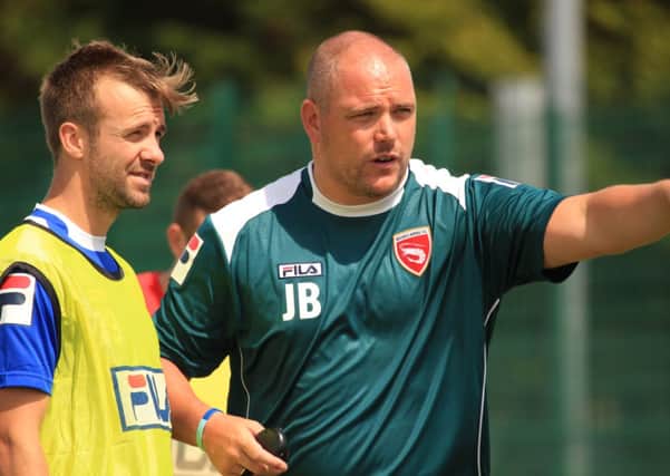 Morecambe manager Jim Bentley hands out instructions to Laurence Wilson during training.
