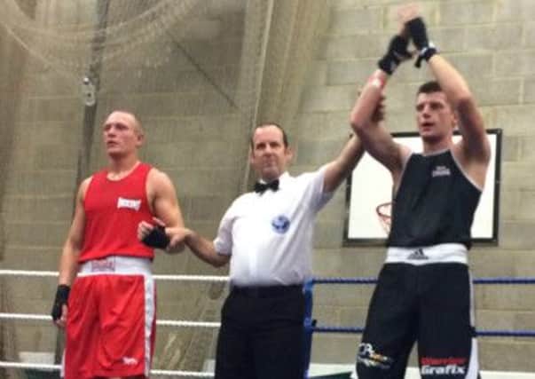 Skerton Boxing Club's Sean Coxon has his hand raised in victory.