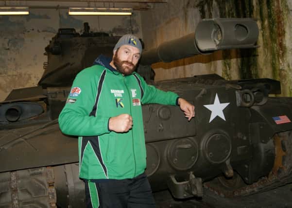 Tyson Fury poses with a tank ahead of his clash with Dereck Chisora.