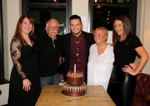 Louise Welfare (left) from Emma's Tea Parties Ltd with the chocolate fudge cake made to welcome home X Factor contestant Paul Akister (centre) seen here with his dad Dave, mum Bev and sister Charlotte.