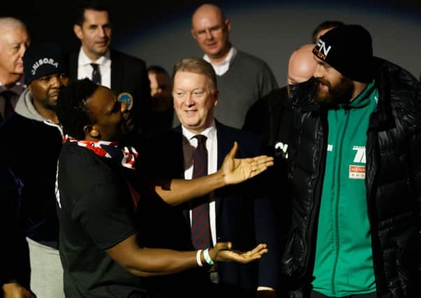 Frank Warren comes between Tyson Fury and Dereck Chisora. Picture: John Walton/PA Wire