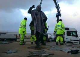 The Eric Morecambe statue is lifted back into place on Morecambe prom.