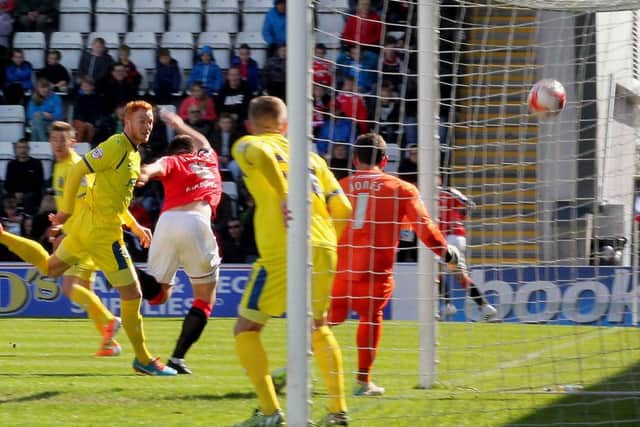 Alex Kenyon heads home Morecambe's first goal against Portsmouth.