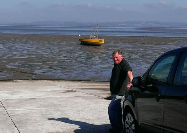 Fisherman Ray Edmondson on the slipway with his boat in the background.