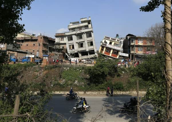 Damaged buildings lean to their sides in Kathmandu, Nepal, Monday, April 27, 2015. A strong magnitude 7.8 earthquake shook Nepal's capital and the densely populated Kathmandu Valley on Saturday, causing extensive damage with toppled walls and collapsed buildings. (AP Photo/Wally Santana)