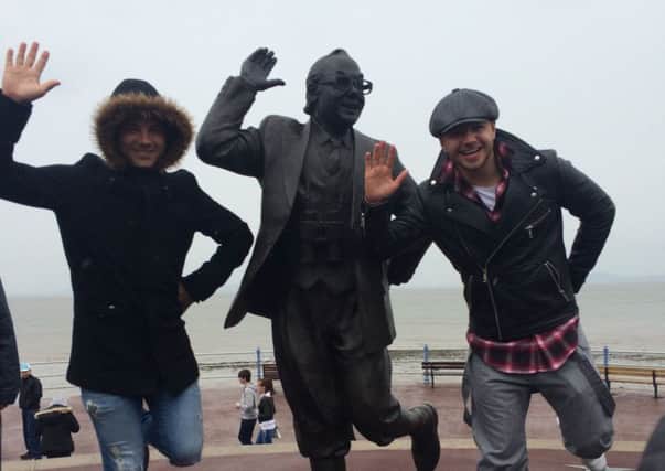 Soap star brothers Ryan and Adam Thomas strike a pose at the Eric Morecambe statue.