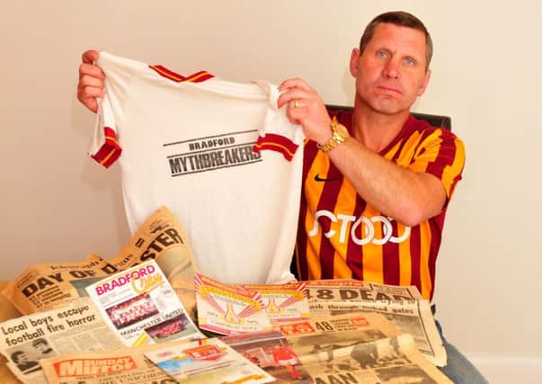Denby Murgatroyd, who was at the Bradford City FC fire 30 years ago, pictured with cuttings and programmes remembering the fire and the shirt he wore on that day.