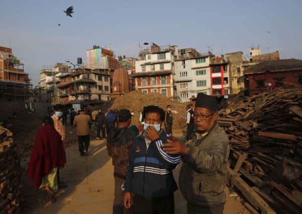 Nepalese men look at buildings damaged in an earthquake at the Durbar Square in Kathmandu, Nepal, Friday, May 1, 2015. The strong magnitude earthquake shook Nepal on Saturday devastating the region and leaving some thousands shell-shocked and displaced. (AP Photo/Manish Swarup)