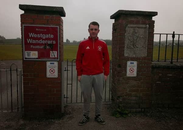 Football coach Eric Shaw stands at the gates of Westgate Wanderers playing field.