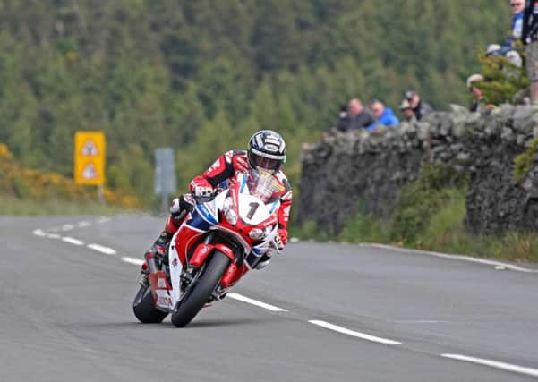 Fans watch as John McGuinness powers his Honda Superbike up the Mountain section of the TT course. Picture: Rod Neill.