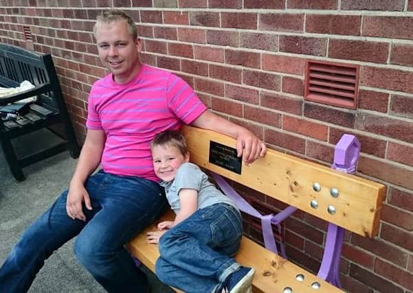 Michael Gilhespy with son Callum on the memorial bench for Emma.
