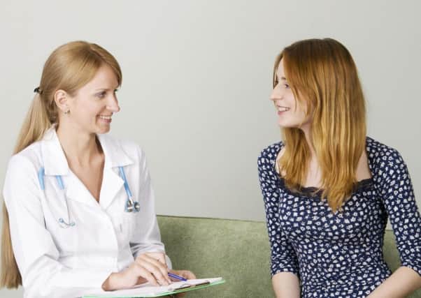 A woman talking to a nurse in a clinic.