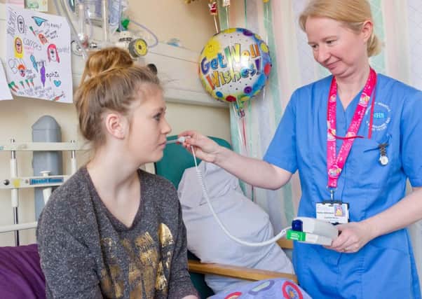 Petra Atkinson, staff nurse, with a young patient on the children's ward.