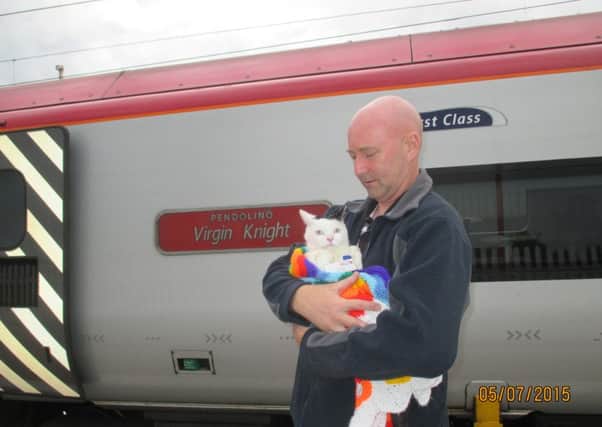 Sir Toby Toblerone the cat, the official mascot for Lancaster train station, with owner Stephen Wilding before his trip on a Pendolino to Penrith.