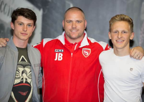 Morecambe boss Jim Bentley with youngsters Jack Kelleher, left, and Charlie Bailey, right, after the pair signed their first professional contracts. Picture: Matt Rushton