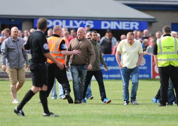 Blackpool fans invade the pitch at Lancaster.