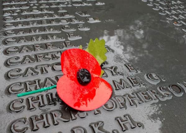 A single poppy lies on the rain soaked names of the fallen at the War Memorial in Lancaster.