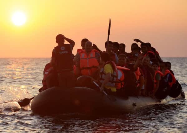 Refugees paddling a rubber dinghy close to the beach at Psalidi near Kos Town, Kos, Greece.  Jonathan Brady/PA Wire.