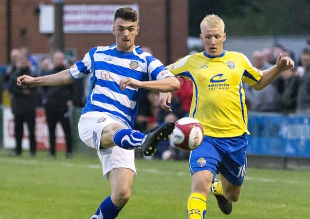 Jacob Davis hooks the ball clear against Warrington Town. Picture: John Hopkins