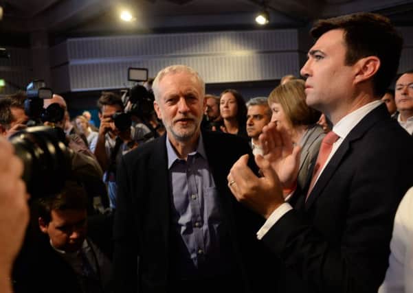 Jeremy Corbyn (centre) prepares to take to the stage after he was announced as the Labour Party's new leader at a special conference at the QEII Centre in London, as defeated candidate Andy Burnham (right) applauds. Photo: Stefan Rousseau/PA Wire