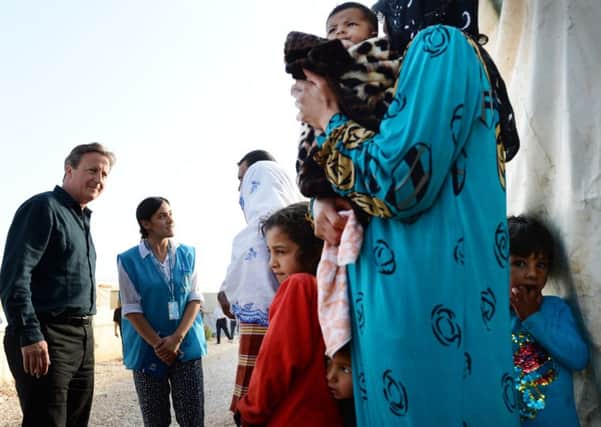 Prime Minister David Cameron meets Syrian refugee families at a tented settlement camp in the Bekaa Valley on the Syrian - Lebanese border. Photo: Stefan Rousseau/PA.
