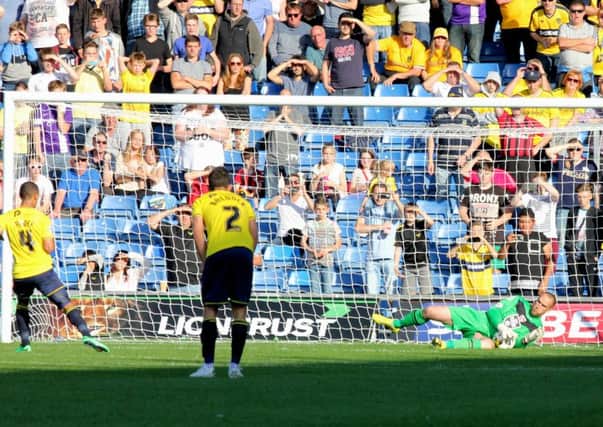Barry Roche saves Kemar Roofe's penalty at Oxford on Saturday.