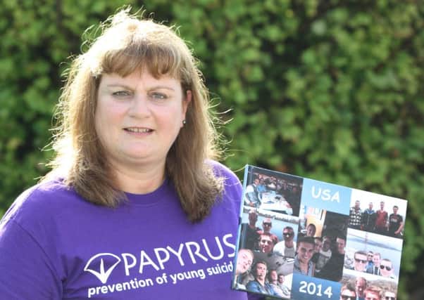 Joanne Towers from Warton is taking part in a walk to raise awareness of young suicides in memory of her son Michael who committed suicide last year. Pictured is Joanne at her home in Warton with a book of Michael's memories created for her by Michael's friends.