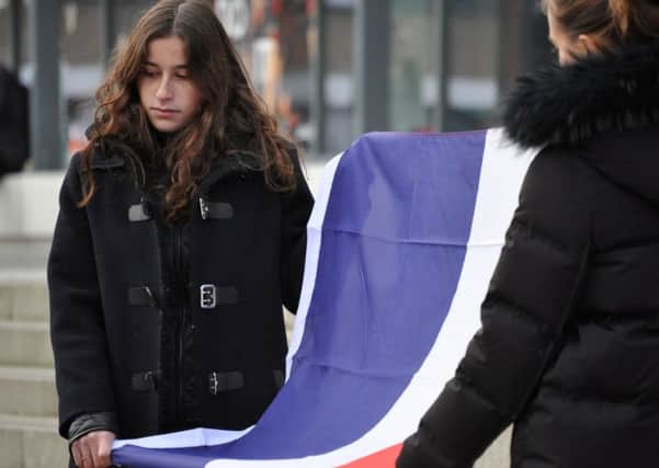 A Lancaster University student with the French flag as students pay their respects to victims of the Paris attacks.