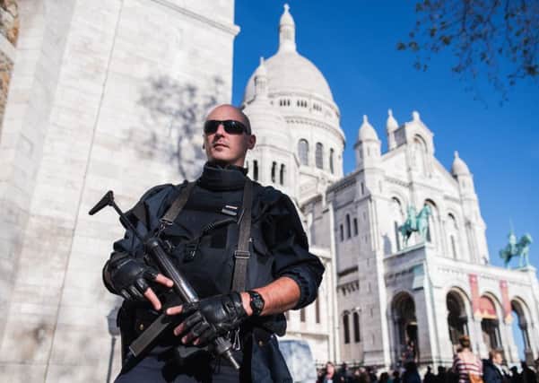 A French police officer patrols at the Sacre Coeur basilica in Paris (AP Photo/Kamil Zihnioglu)