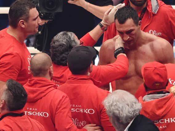 Wladimir Klitschko is consoled by his team as his titles slip away.