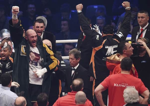 Tyson Fury celebrates after winning Wladimir Klitschko's, right,  WBA, IBF, WBO and IBO belts. AP Photo/Sebastian Konopka