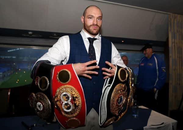 Tyson Fury holds his belts during a homecoming event at the Macron Stadium, Bolton. Simon Cooper/PA Wire