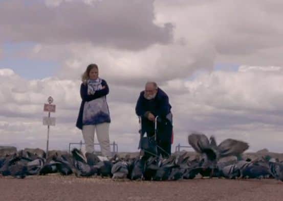 John Wilkinson feeds pigeons on Morecambe seafront with his friend Robyn Holtham. Picture from ITV1's 'Britain's Oldest Crooks'.