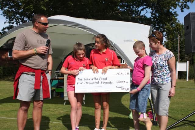 Andy , Sandy and Gabriella Benn are presetned with the £5,000 cheque fro by Fun run organisers  Katie Olvier and Ella Bookless