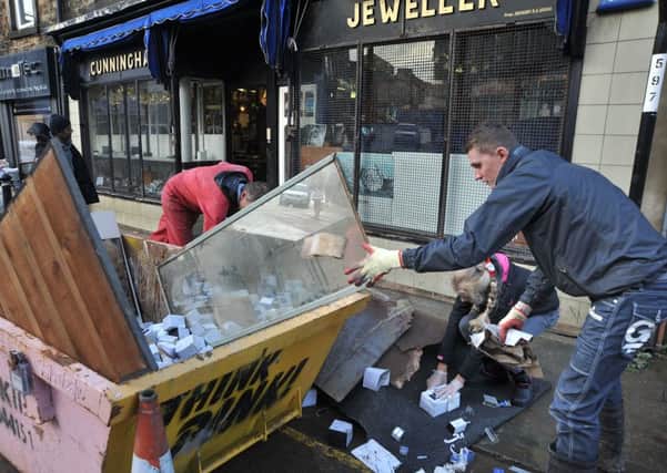 Aftermath of the unprecedented flooding over the weekend in Lancaster.
Members of the Gregg family fill a skip with the ruined contents of their business, Cunningham Jewellers on Chapel Street.  PIC BY ROB LOCK
7-12-2015