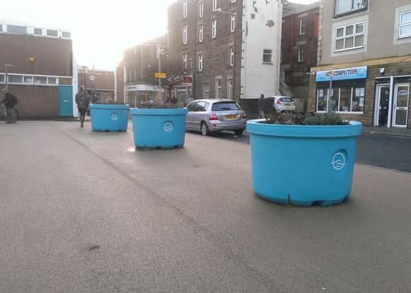 The three turquoise tubs that have been placed on the yellow surfacing at the top of the car park on Pedder Street in Morecambe.