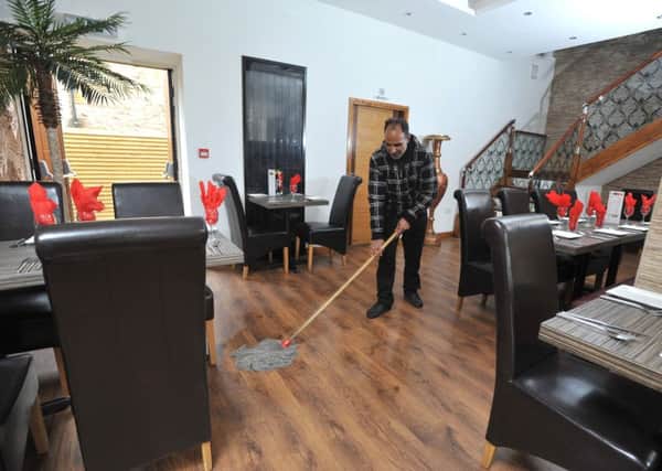 Photo Neil Cross
Taj Hussain at the Kashish restaurant in Lancaster  where workmen are repairing damage caused by floods