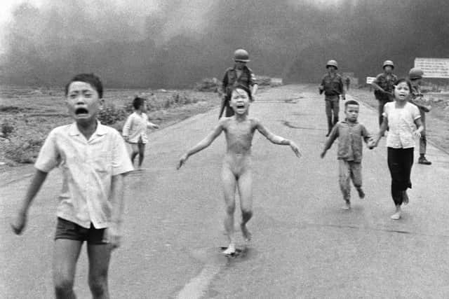 FILE - In this June 8, 1972 file photo, crying children, including 9-year-old Kim Phuc, center, run down Route 1 near Trang Bang, Vietnam after an aerial napalm attack on suspected Viet Cong hiding places as South Vietnamese forces from the 25th Division walk behind them. A South Vietnamese plane accidentally dropped its flaming napalm on South Vietnamese troops and civilians. From left, the children are Phan Thanh Tam, younger brother of Kim Phuc, who lost an eye, Phan Thanh Phouc, youngest brother of Kim Phuc, Kim Phuc, and Kim's cousins Ho Van Bon, and Ho Thi Ting. (AP Photo/Nick Ut, File)