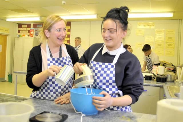 Learning Support Assistant Nicola Cragg assists Jamie-Leigh Jacklin as they make biscuits at Chadwick High School, Lancaster