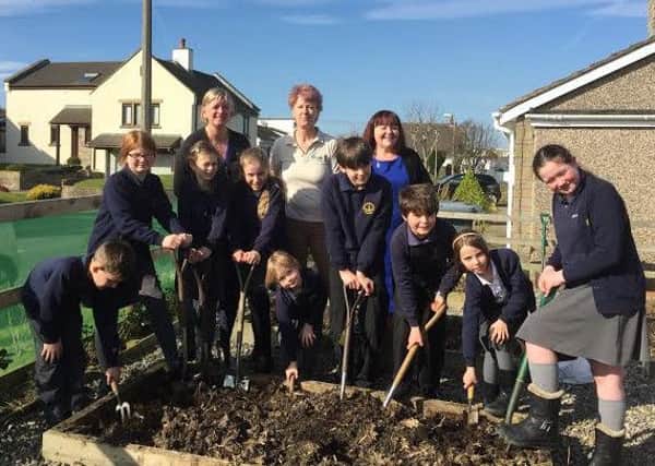 Gillian Thomas (headteacher), Jayne Weatherill (school business manager) and Mel Wagstaff of The Lantern CafÃ© Bistro pictured with some of the green fingered pupils.