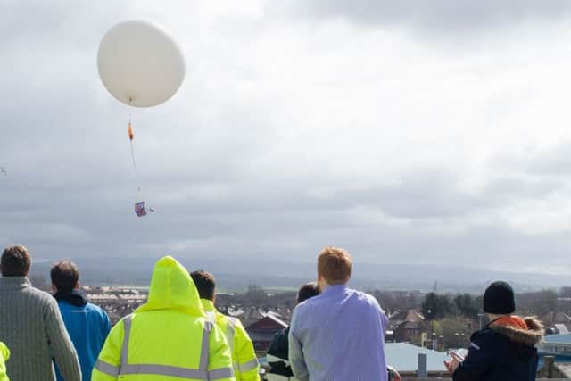 The cuddly canine is launched high above Morecambe as the launch party looks on from the Midland Hotel roof.