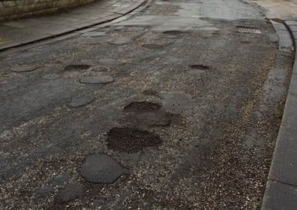 The surface of Thonock Road, Westgate, is riddled with potholes.