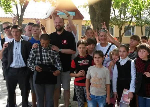 James Urquhart and Julie Dowd with other volunteers and local children during the 2015 Phoenix convoy.