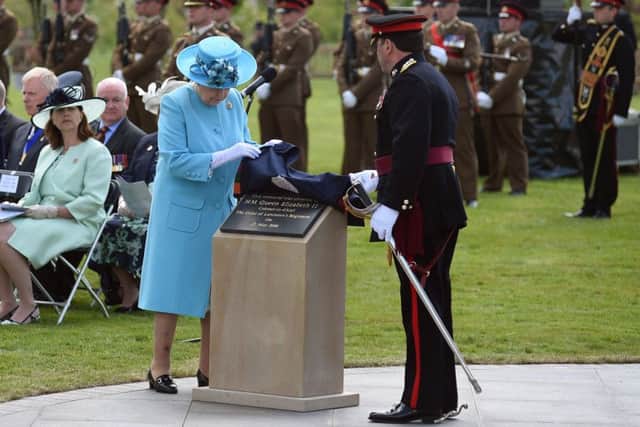 Queen Elizabeth II unveils a plaque during a service at the National Memorial Arboretum in Alrewas, Staffordshire, in tribute to soldiers from the Duke of Lancaster's Regiment. Photo: Joe Giddens/PA Wire
