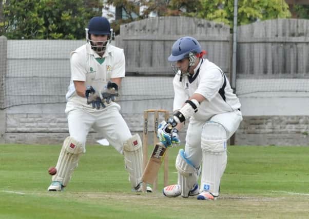 Morecambe wicketkeeper Lewis Edge looks on as Gurman Bains goes to work for St Annes at the top of the order.
