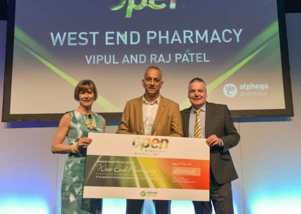 Sue Moore and Martin Queen of Alphega Pharmacy present winners cheque and trophy to Vipul Patel.