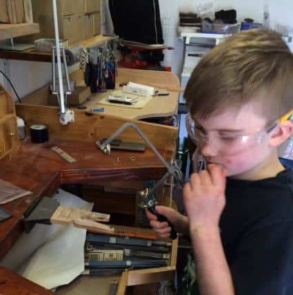 Dillon Hearne making the jewellery in his mum's studio.