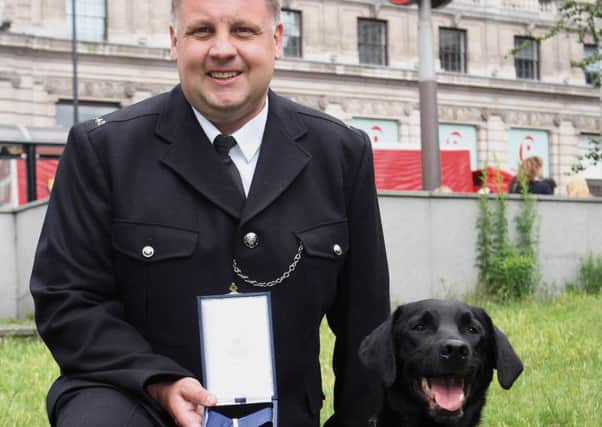 Labrador Vinnie and PC Dave Coleman with the PDSA gold medal.