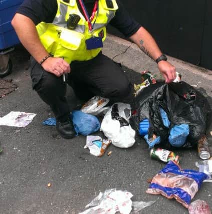 Phil Bradley examines a pile of rubbish dumped in a Morecambe alleyway.